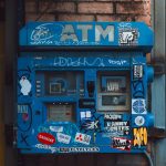 Graffiti-Covered ATM on Brick Wall – Financial Crime Risk Illustration